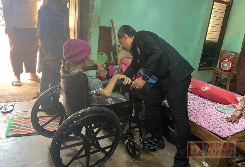 Junarso membantu Ibu Wartinah memakai Kursi roda
